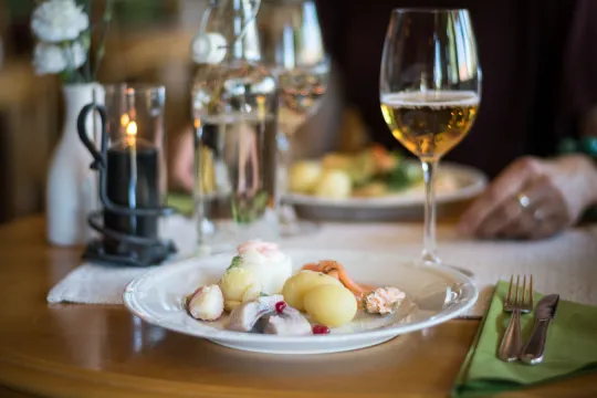 Servitör som dukar upp middag på bord.