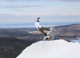En snowboardåkare flyger i ett hopp.