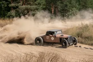 Äldre bil sladdar i en kurva.