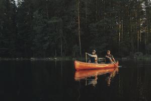 Två människor som paddlar kanot