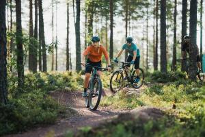 Två cyklister i skogen.