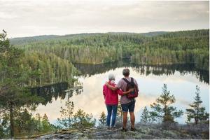 Par som står på ett berg och kollar ner på en sjö.