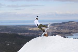 En snowboardåkare flyger i ett hopp.