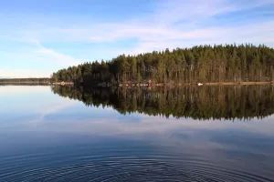 Spegelblank sjö i skymning.