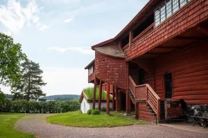 Ornässtugan, en röd byggnad med gröna träd runtom.