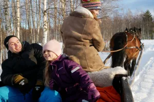 Familj åker häst och släde.