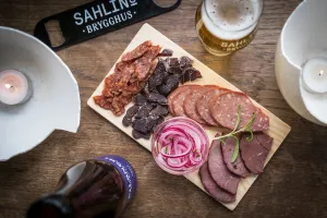 Charkbricka med olika korvar och tillbehör.