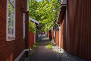 En trång gränd bland röda trähus i Falun.