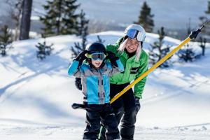 Barn och skidlärare åker lift på Idre Himmelfjäll.