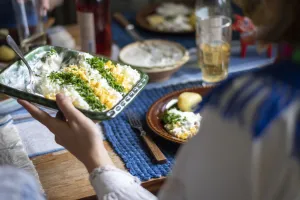 Kvinna håller i form med midsommarmat.