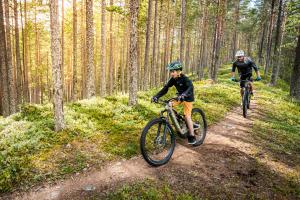 Vuxen och barn cyklar mountainbike i Rörbäcksnäs. 