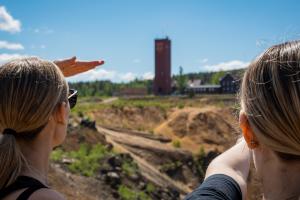 Två personer blickar ut över dagbrottet Stora Stöten vid Falu Gruva i Världsarvet Falun.