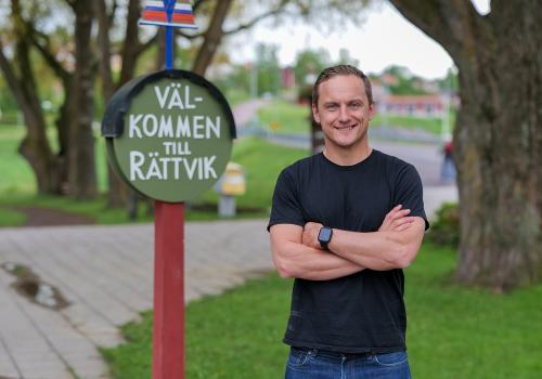 Jojje Borssén i svart tröja, bredvid en skylt med texten Välkommen till Rättvik.