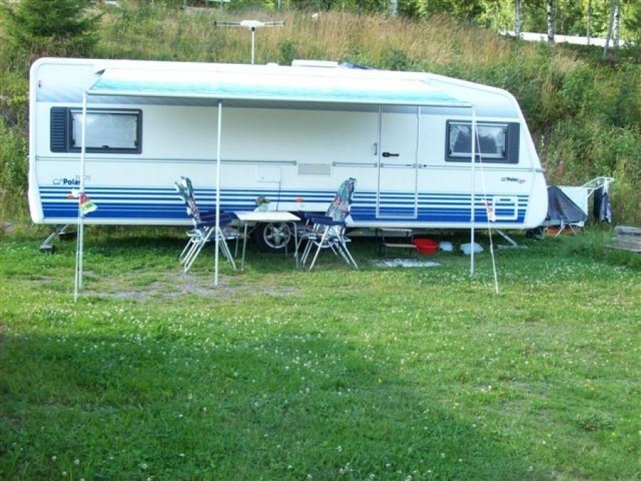 A caravan with a table and chairs outside.