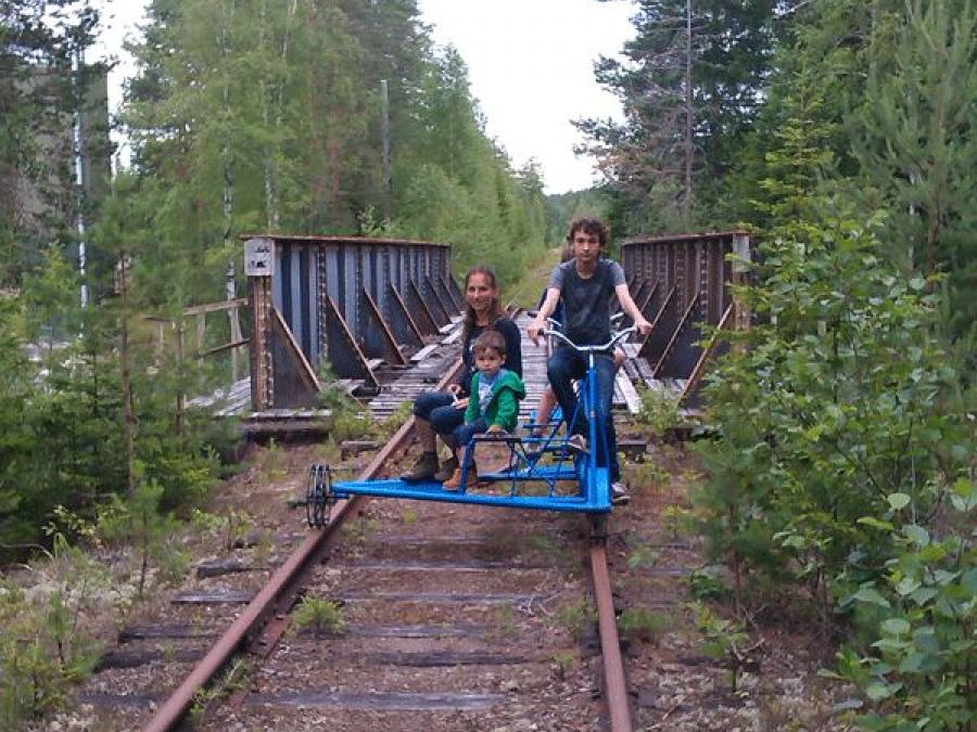 Family is sitting on a rail trolley.