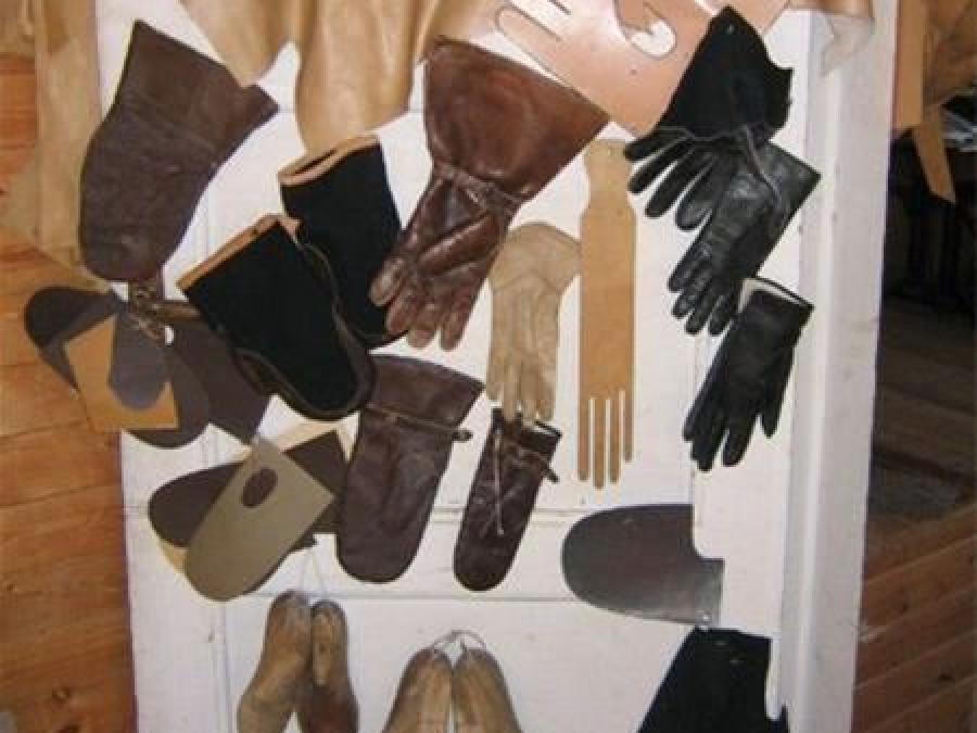 Several leather products such as gloves hang on the wall