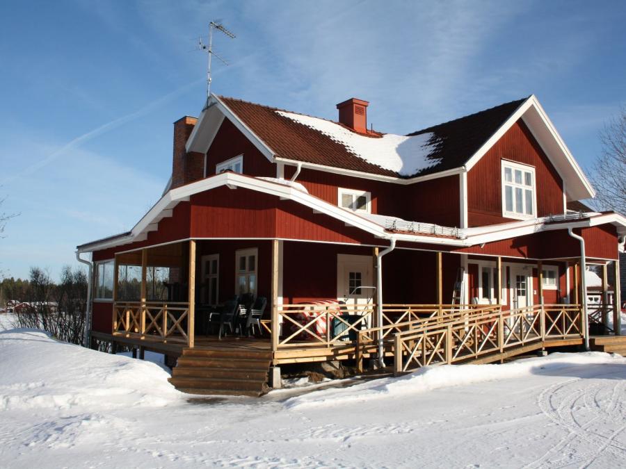 Röd villa med stor altan en vinterdag.