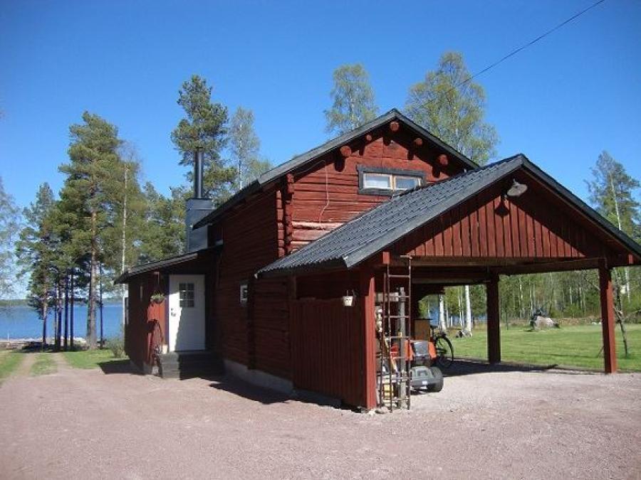 Red log-cabin with the lake Siljan in the background.
