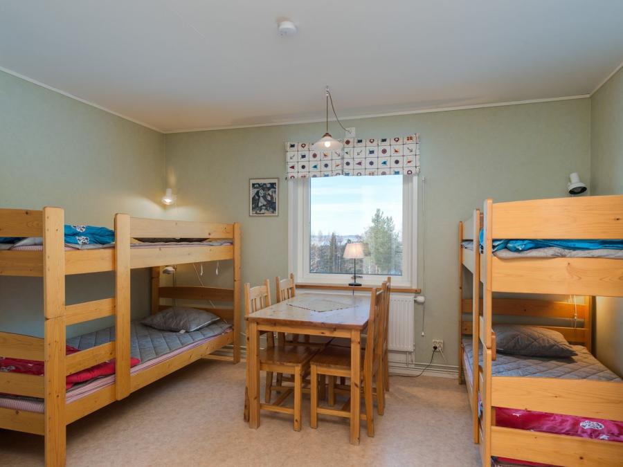 Bedroom with two bunkbeds and a table in the middle. 