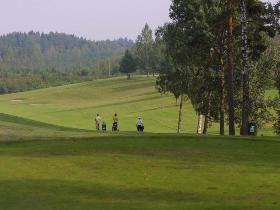 Three people on golf course.