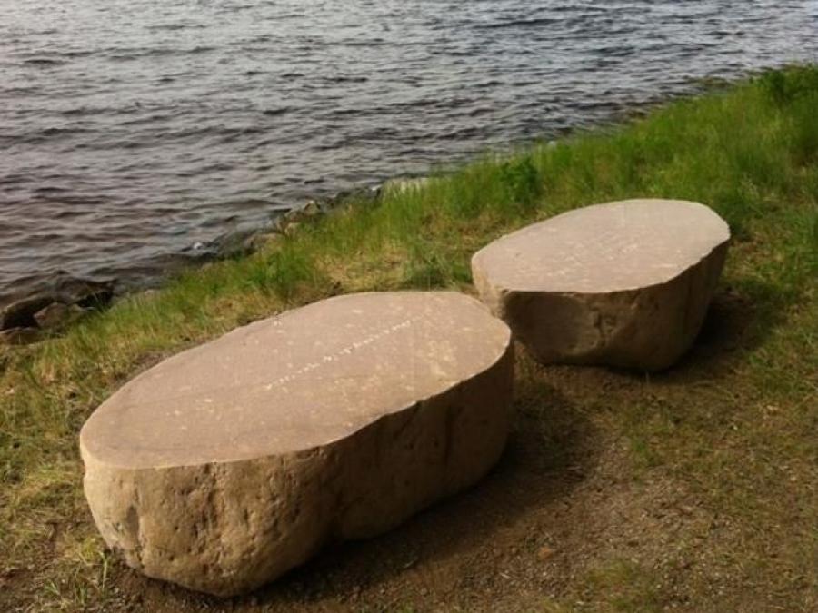 Two stones next to a lake.