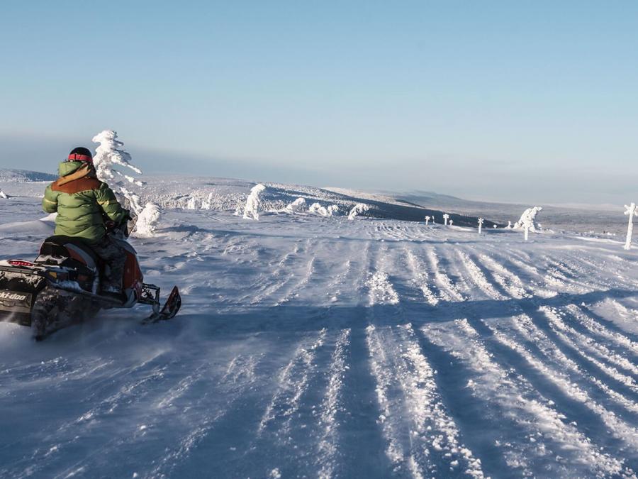 A driver on a scooter drives from the camera out onto the white expanses.
