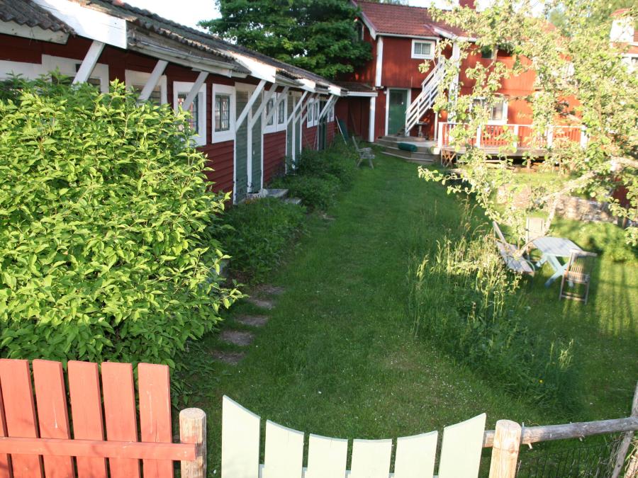 Grind till rödmålade längor med rum på Leksands Lustgård. 