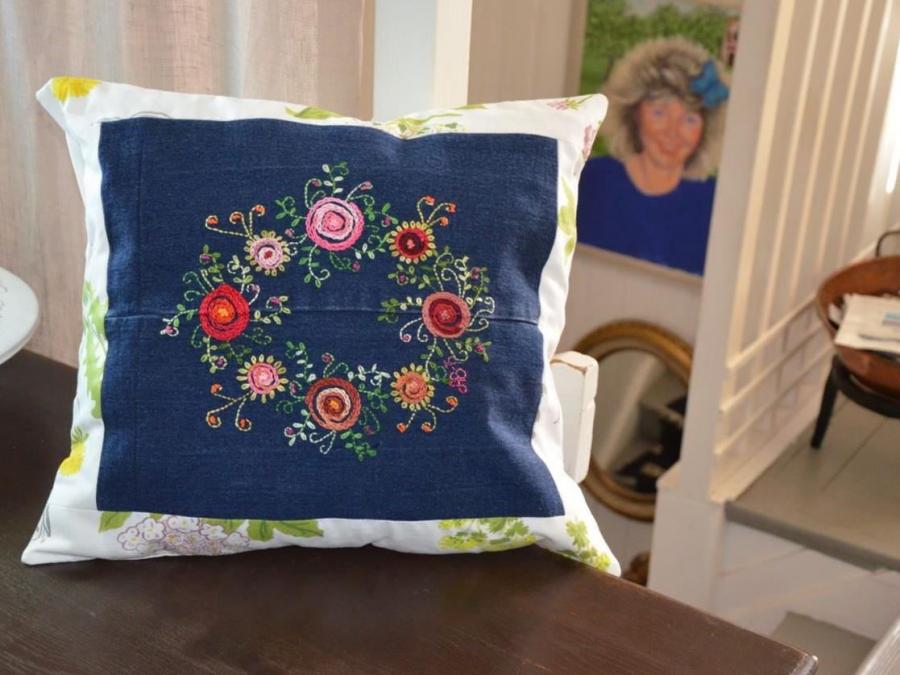 Hand-embroidered pillow in floral pattern.