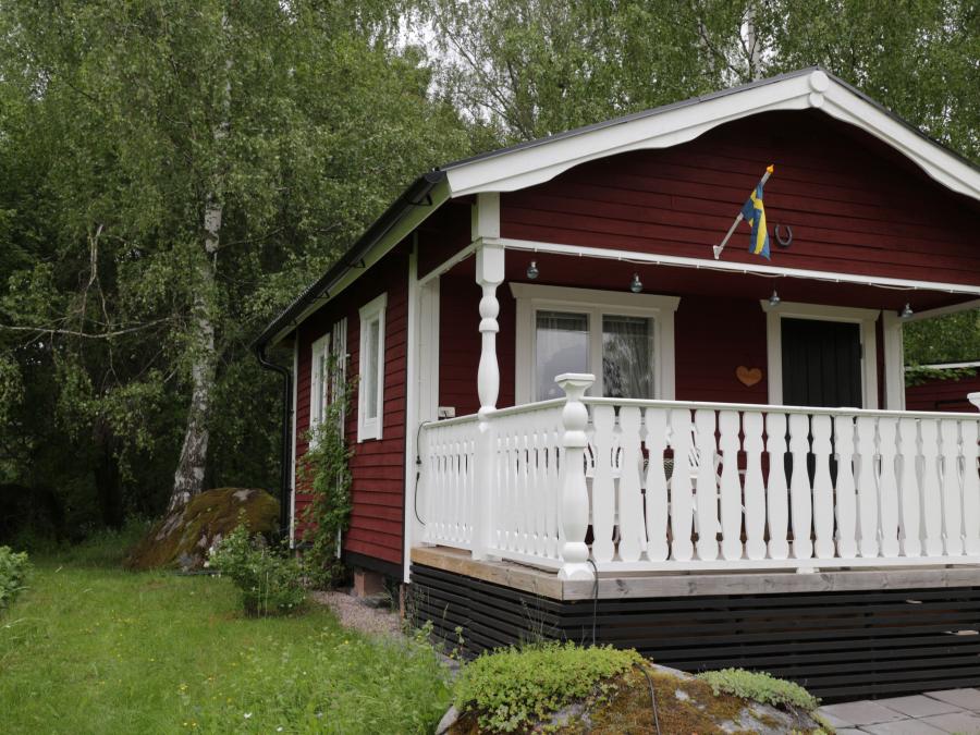 Red painted cottage with a white veranda.