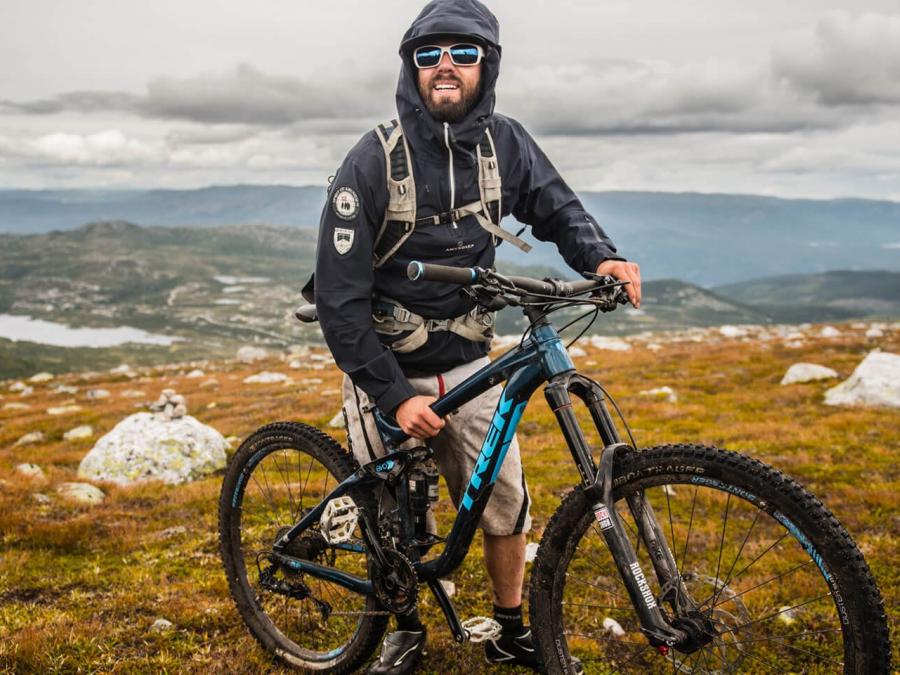 A man with his bike on the mountain. 