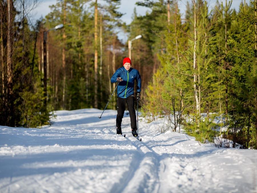 A women skiing in the trails on a sunny day.