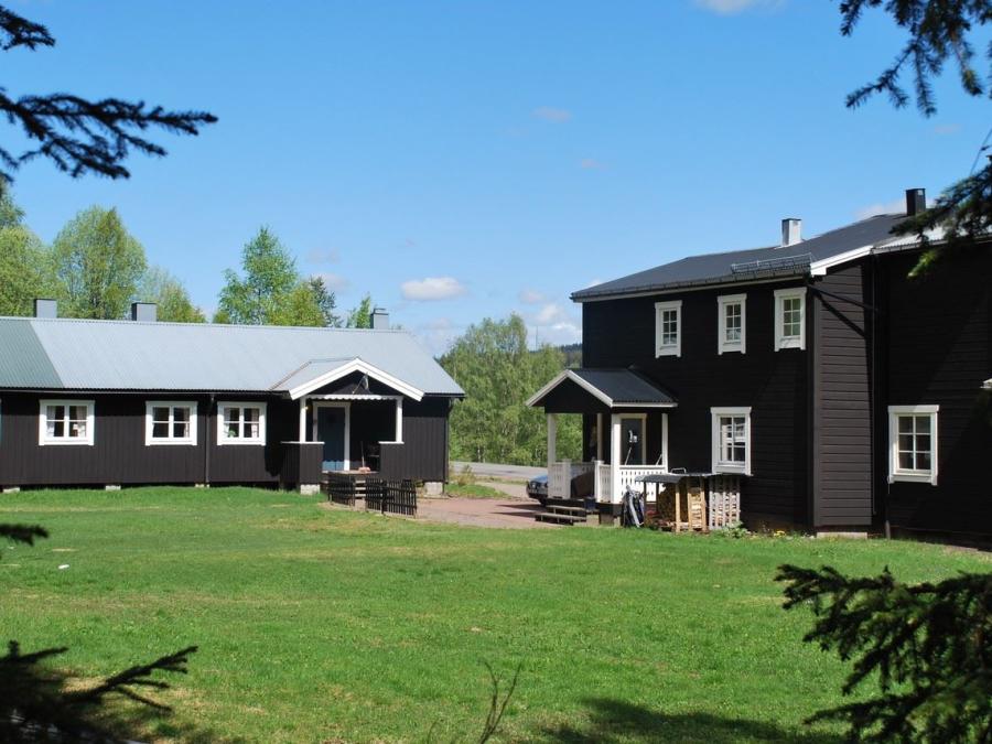 Försgården's brown housesin summer greenery.