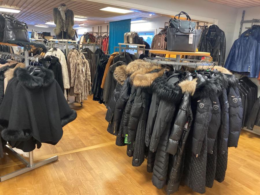 Several clothes racks with jackets in the store.