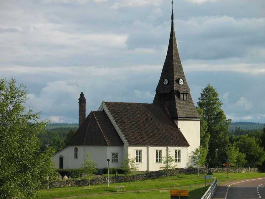 Venjans kyrka på sommaren med berg i horisonten. 