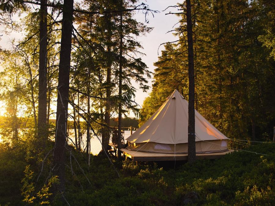 Altan med ett glamping tält i solnedgång.