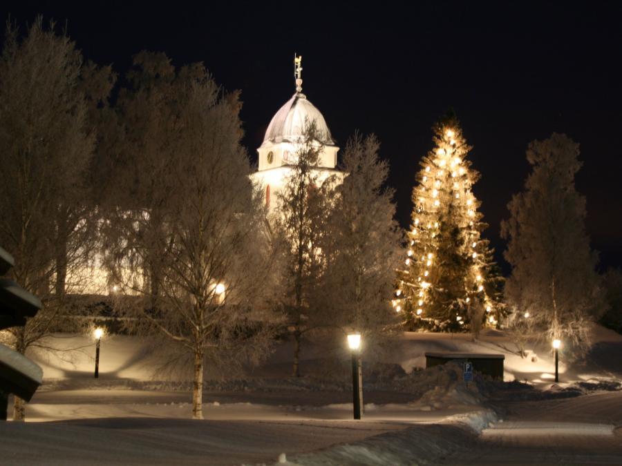 Rättviks kyrka med snö och gran med lysen.
