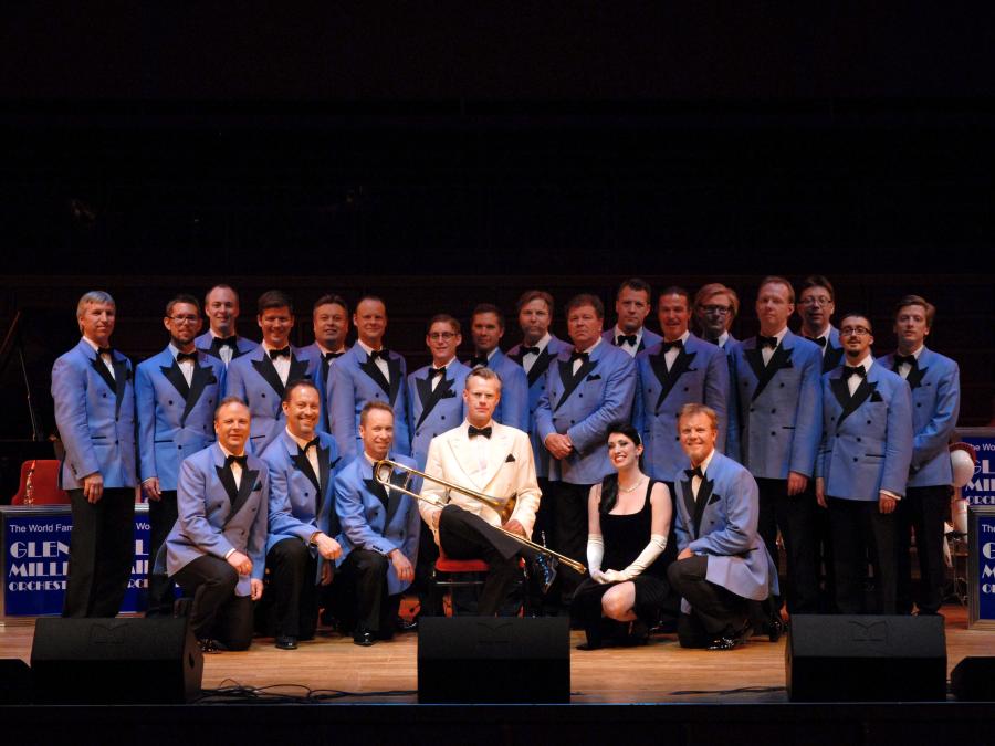 Glenn Miller Orchestra på scenen iklädd blå kostym. 