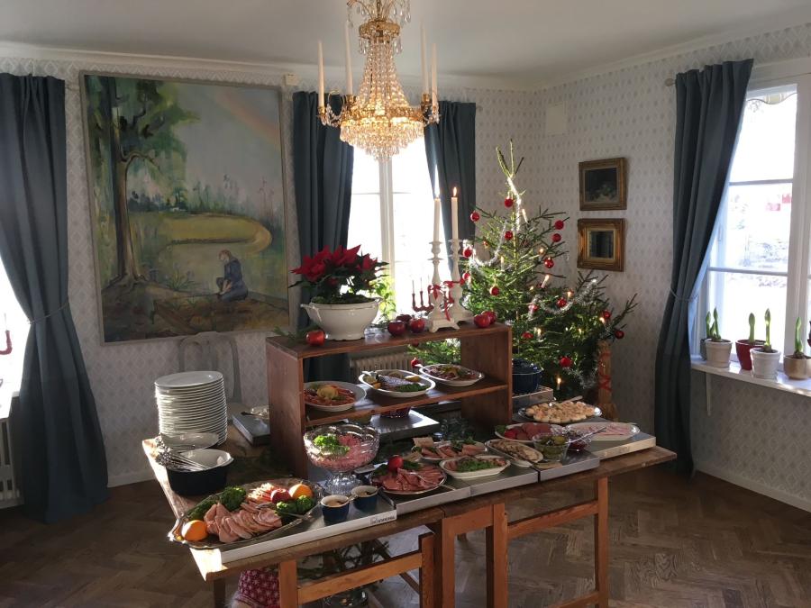 Dukat bord med julmat och julgran i bakgrunden. 