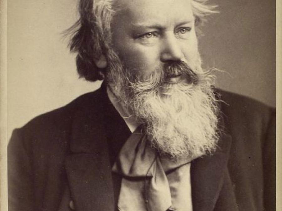 Ett svartvitt fotografi på en man i skägg och mustasch föreställande Johannes Brahms.