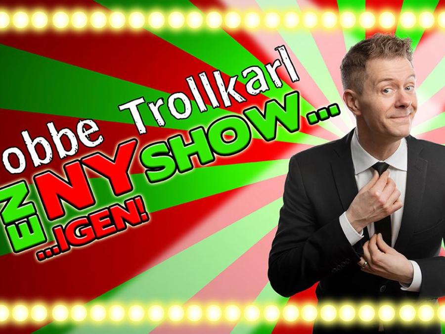 Grön och röd bakgrund, en man i mörk kostyn och vit skjorta som har händerna på sin slips, text Tobbe Trollkarl en ny show igen.