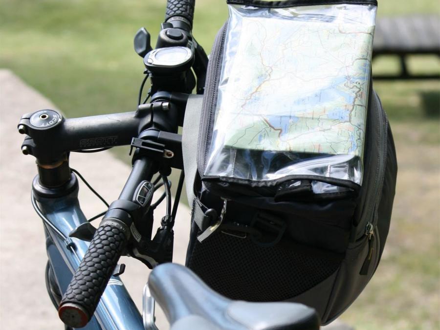 Cykel med en cykelväska och i väskan syns en karta tydligt.