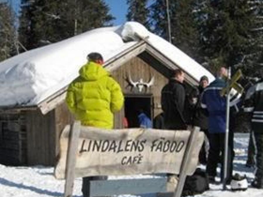 People who are on their way into the waffle house. Winter. Sign in front where it says Lindalen's summer pasture.