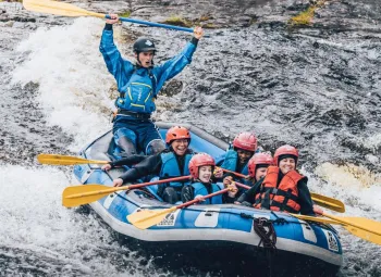 Sex personer i en gummibåt i en fors.