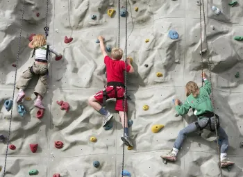 Barn klättrar uppför en klättervägg