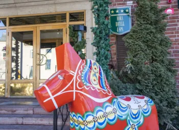 En staty av en röd häst framför en byggnad.