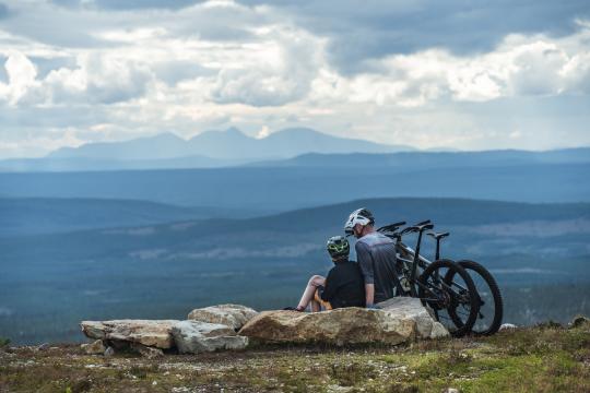 Two persons on a mountain with their bikes.
