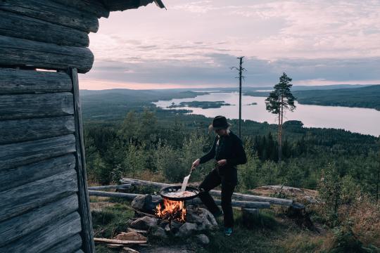 A person cooking food out in the nature.