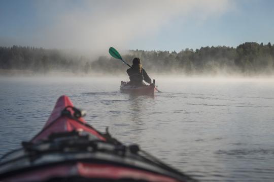 Two people kayaking on a lake.