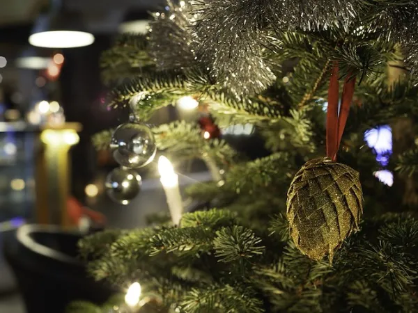 Fint klädd julgran med kottar, kulor och glitter.