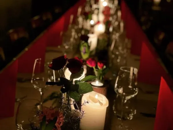 Set table with red cloth and candles. 